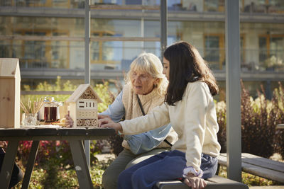 Woman and girl making bug hotels together