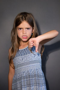 Portrait of a teenage girl against gray background