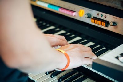 Cropped hands of woman playing piano