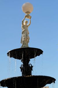 Low angle view of statue against clear blue sky