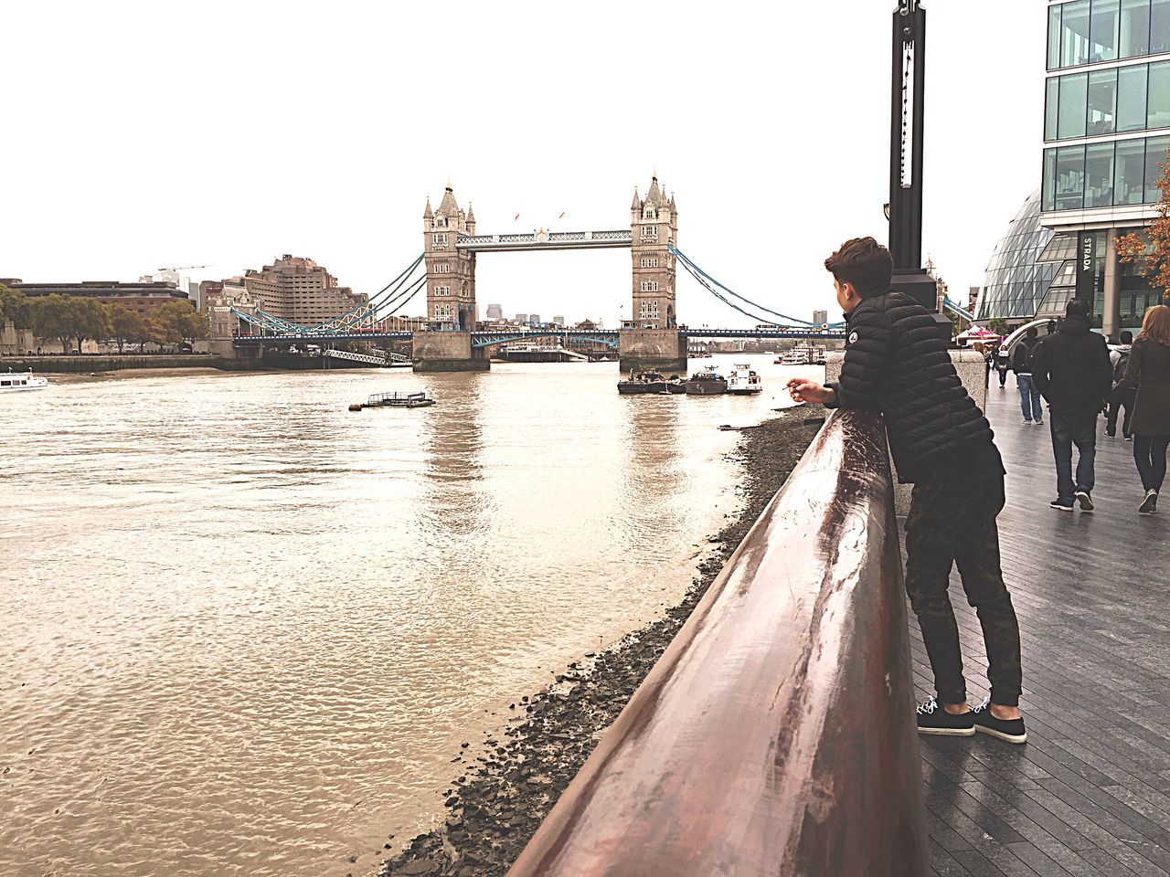 built structure, architecture, water, clear sky, transportation, building exterior, men, nautical vessel, person, lifestyles, mode of transport, city, river, leisure activity, bridge - man made structure, travel, city life, large group of people, boat