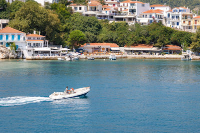 Sailboats in sea against buildings in city