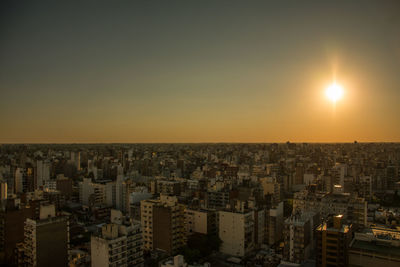 Aerial view of illuminated buildings in city against clear sky