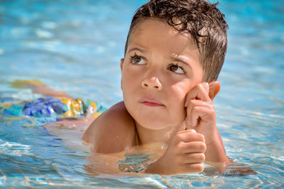 Portrait of a cute little child swimming in a pool