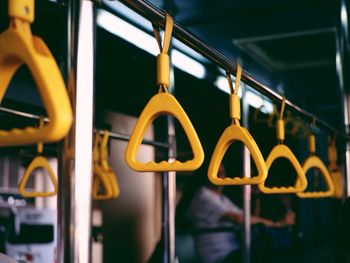 Close-up of yellow handles in train