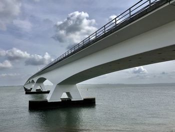 Low angle view of bridge over sea against sky