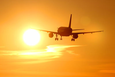 Airplane flying in sky during sunset