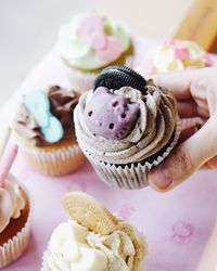 Close-up of cropped hand holding cupcake