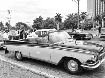 Cars on street in city against sky