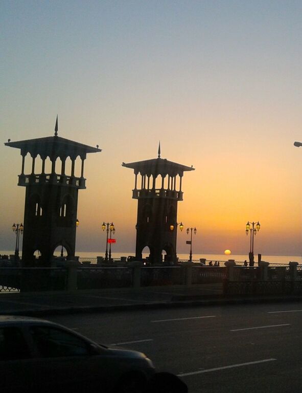 sunset, transportation, clear sky, built structure, architecture, copy space, silhouette, road, orange color, car, sky, travel, street light, building exterior, land vehicle, outdoors, dusk, street, mode of transport, guidance