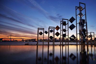 Bridge over river against sky during sunset