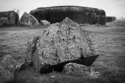 Close-up of damaged rock on field against sky