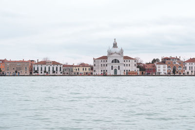 View of sea by cityscape against sky