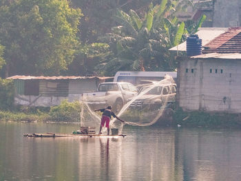 Full length of man by house on lake against building