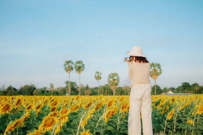 Low angle view of woman standing on field against sky