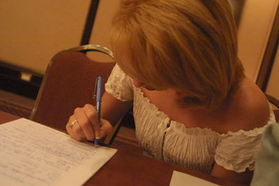 Midsection of woman reading book while sitting on table