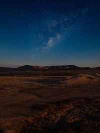 Scenic view of landscape against star field at night