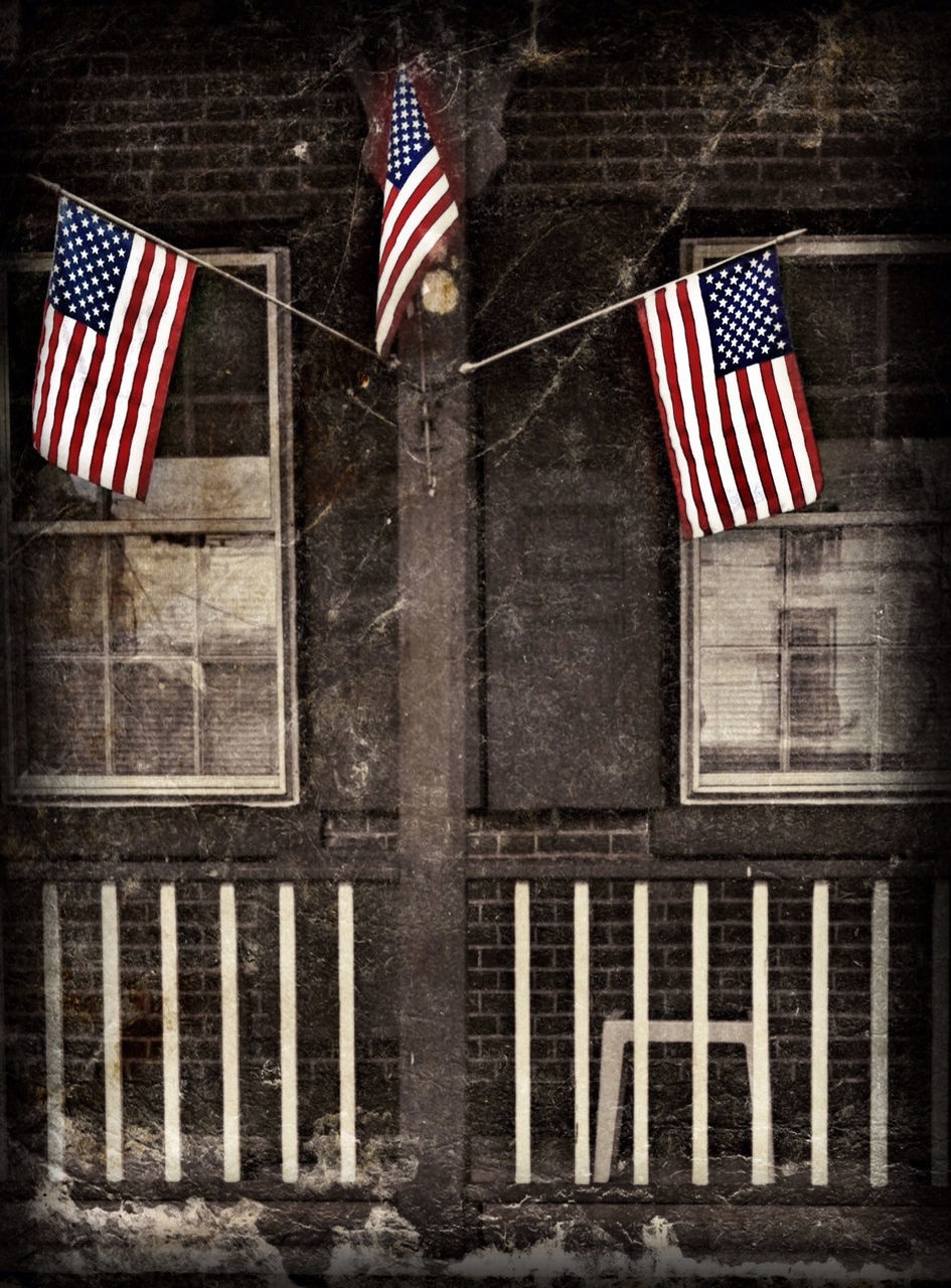 flag, patriotism, architecture, building exterior, identity, american flag, national flag, built structure, striped, red, low angle view, day, window, sunlight, guidance, no people, building, culture, city, outdoors