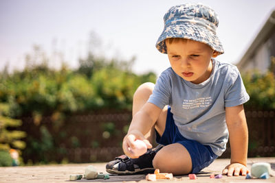 Full length of boy drawing on footpath