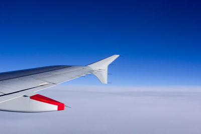 Airplane wing against blue sky