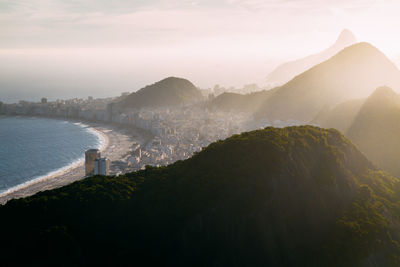 Scenic view of sea and mountains against sky