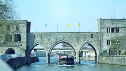 Bridge over river against buildings in city