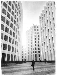 Man walking in city against sky