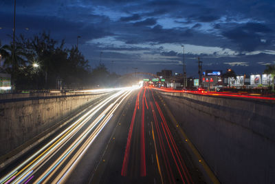 Light trails on road against sky at night