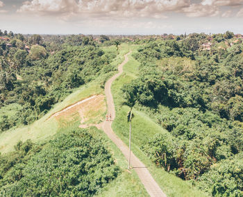 High angle view of road amidst trees against sky