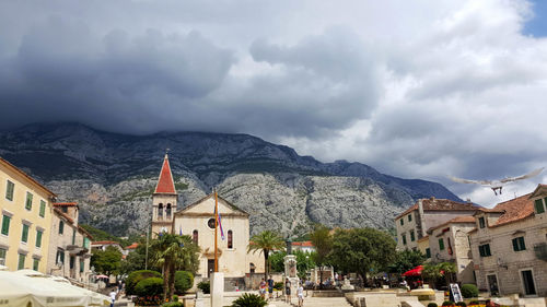 Houses in town against cloudy sky