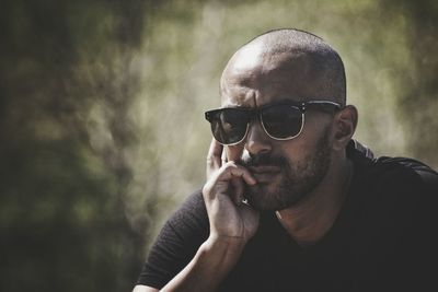 Close-up of man smoking on sunglasses