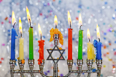 Close-up of colorful candles burning against decorations