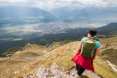 Rear view of female hiker with backpack standing on mountain