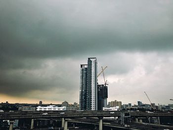 Buildings in city against cloudy sky