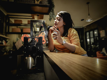 Full length of woman sitting at restaurant table