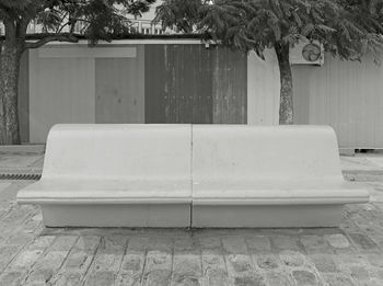 Monochrome empty concrete bench on the urban sidewalk