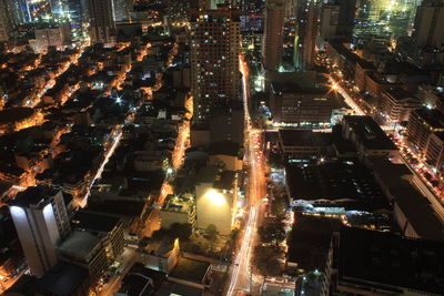 High angle view of illuminated street amidst buildings at night