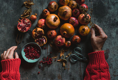 Midsection of woman holding fruits on table