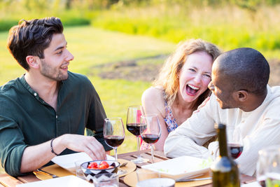 Side view of friends toasting drinks at restaurant