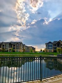 Canal by building against sky