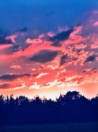 Silhouette trees by lake against sky during sunset