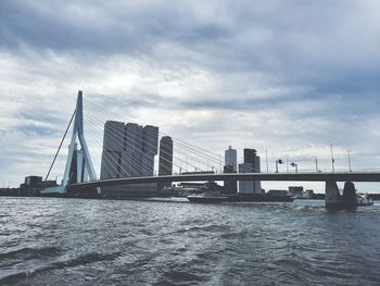 Bridge over river in city against sky