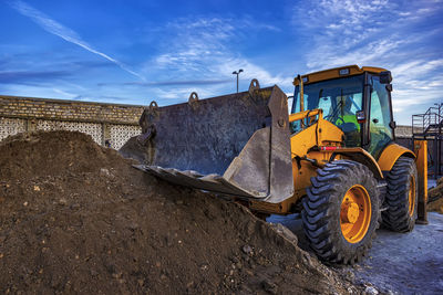 Construction site by road against sky