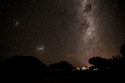 Silhouette trees against sky at night