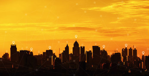Digital composite image of buildings in city during sunset