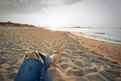 Low section of man relaxing on beach