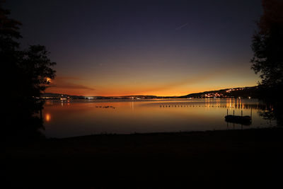 Scenic view of lake against sky at night