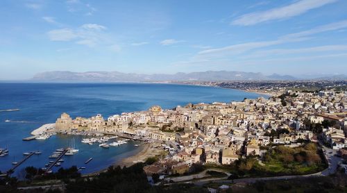 High angle view of city by sea against sky