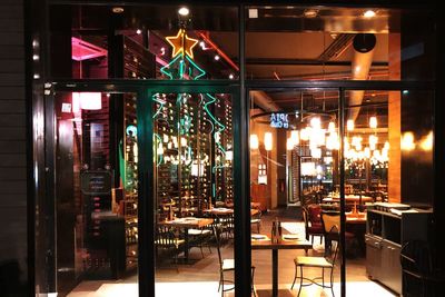 Illuminated restaurant by street at night