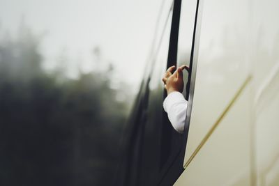 Low angle view of person touching bus window